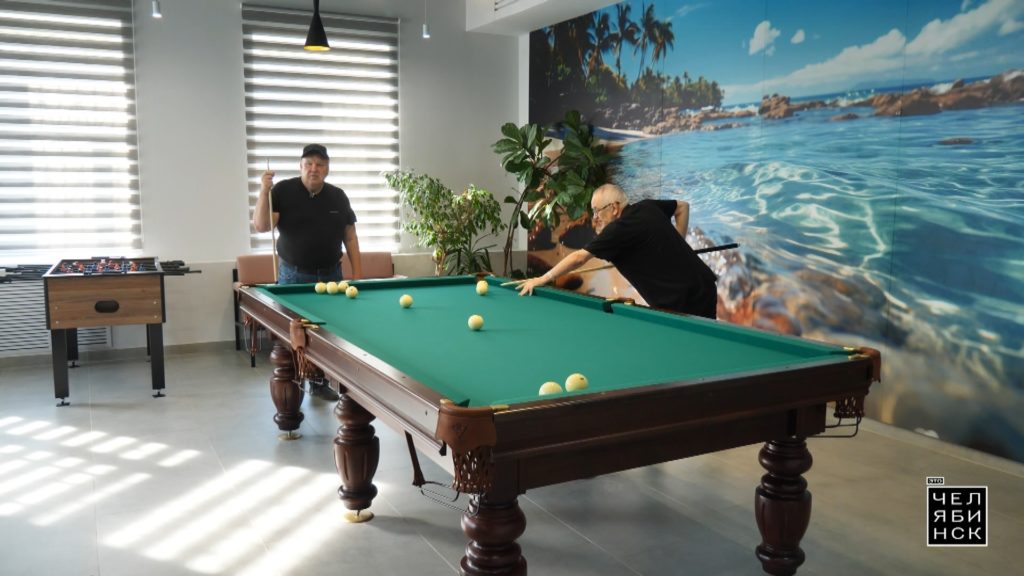 Гости центра активного долголетия играют в бильярд